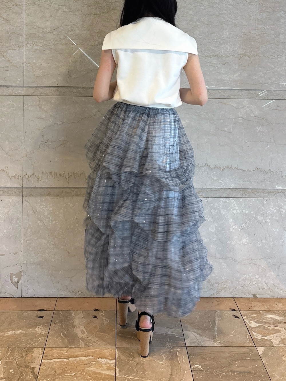ホワイト系のTシャツ/カットソー、ブルー系のスカート、ブラック系のサンダルを着用したレディースの夏コーディネートの3枚目の写真