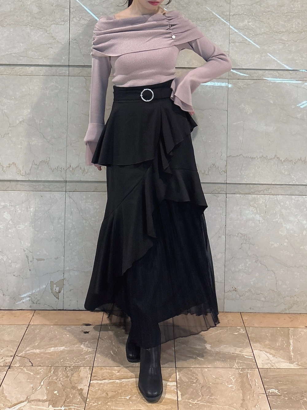 ブラック系のスカート、ピンク系のニット/セーター、ブラック系のブーツを着用したレディースの冬コーディネートの2枚目の写真