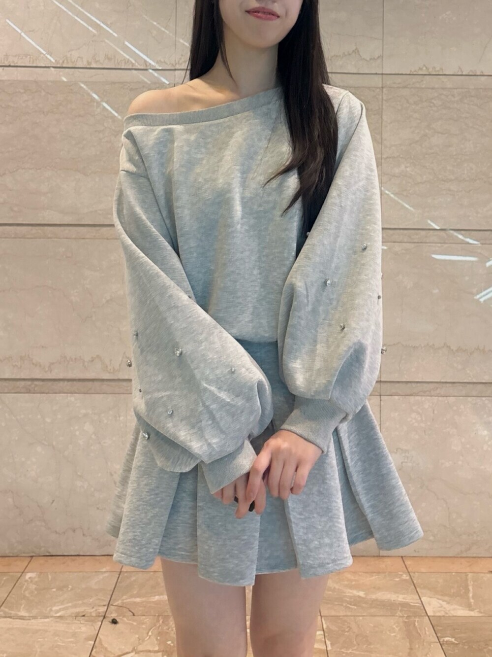 ブラウン系のブーツ、グレー系のスウェット、グレー系のスカートを着用したレディースの秋コーディネートの5枚目の写真