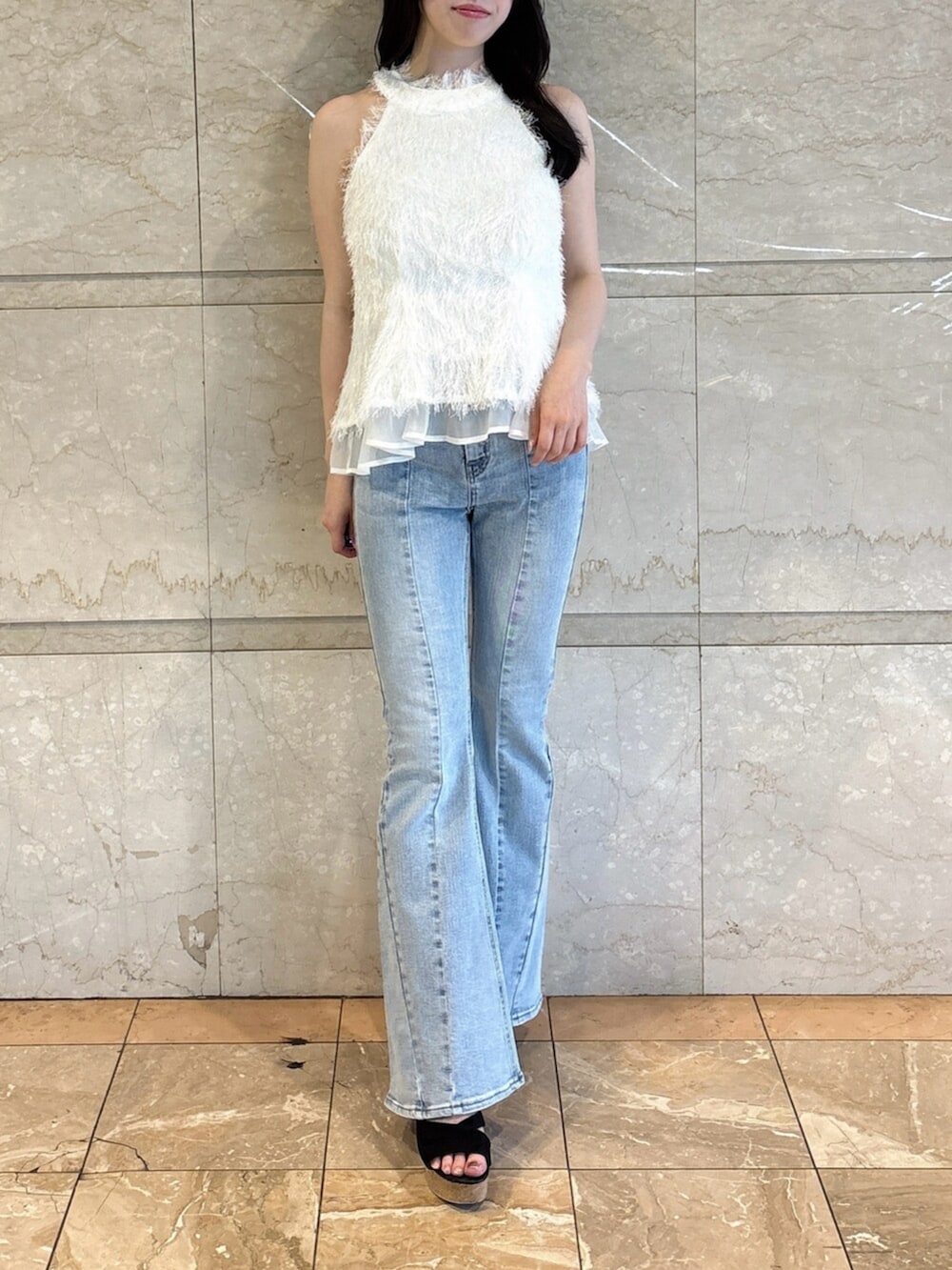 ブラック系のサンダル、ブルー系のデニムパンツ、ホワイト系のタンクトップを着用したレディースの夏コーディネートの2枚目の写真