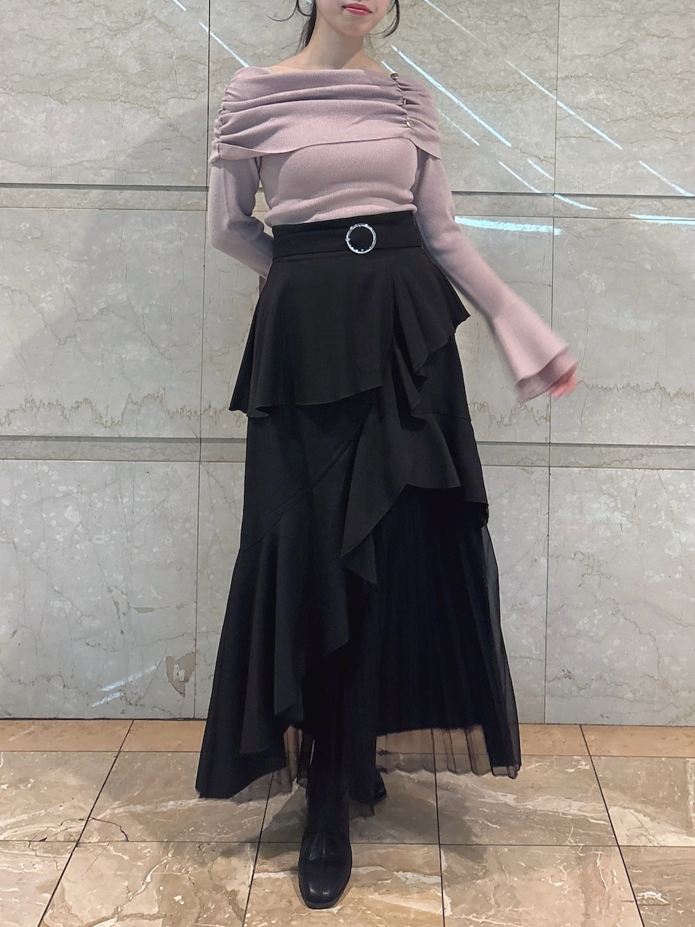 ブラック系のスカート、ピンク系のニット/セーター、ブラック系のブーツを着用したレディースの冬コーディネートの4枚目の写真