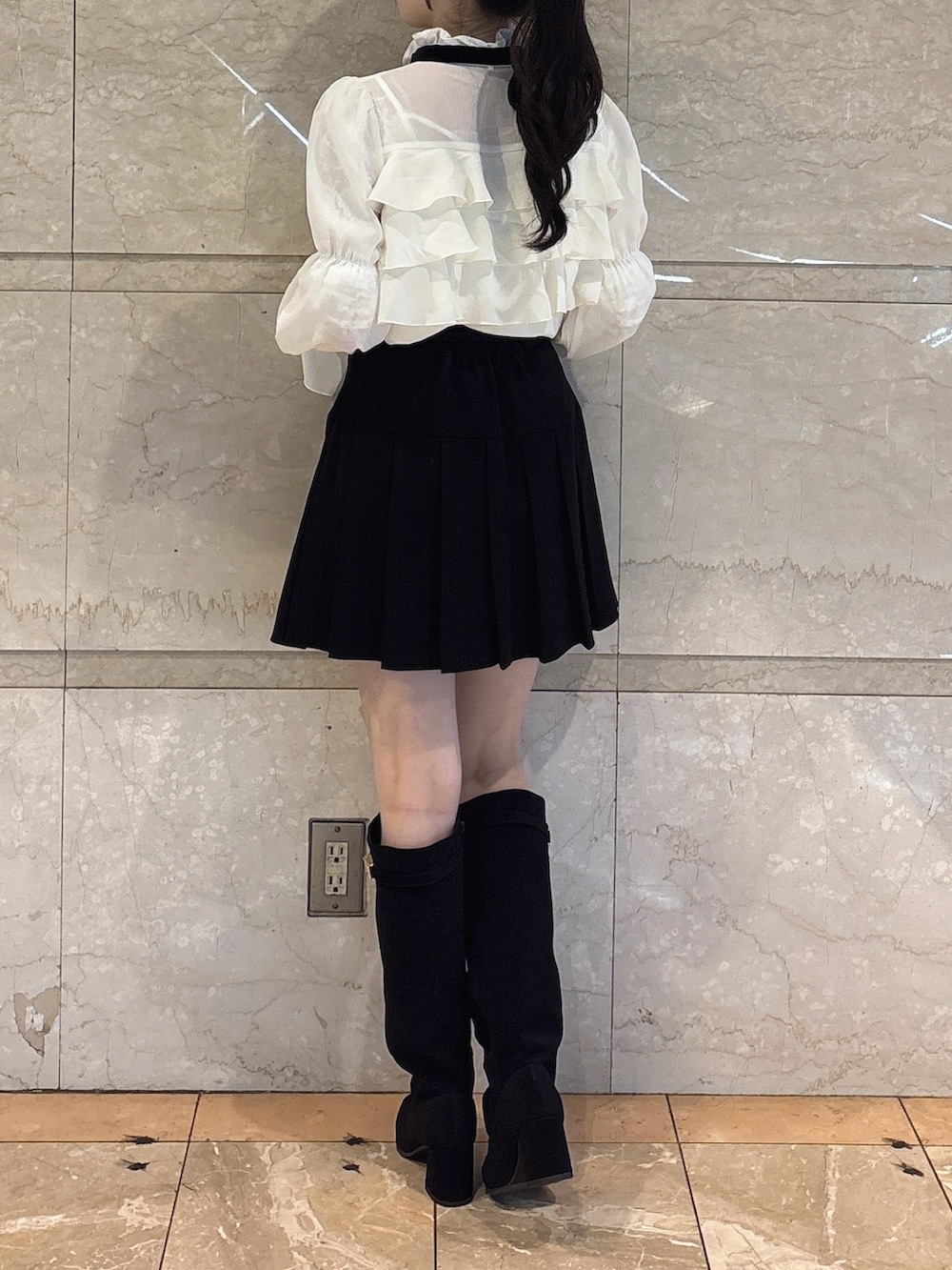 ホワイト系のシャツ/ブラウス、ブラック系のスカート、ブラック系のブーツを着用したレディースの秋コーディネートの3枚目の写真