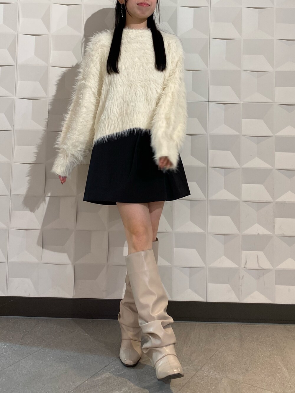 ホワイト系のニット/セーター、ブラック系のスカートを着用したレディースの秋コーディネートの3枚目の写真