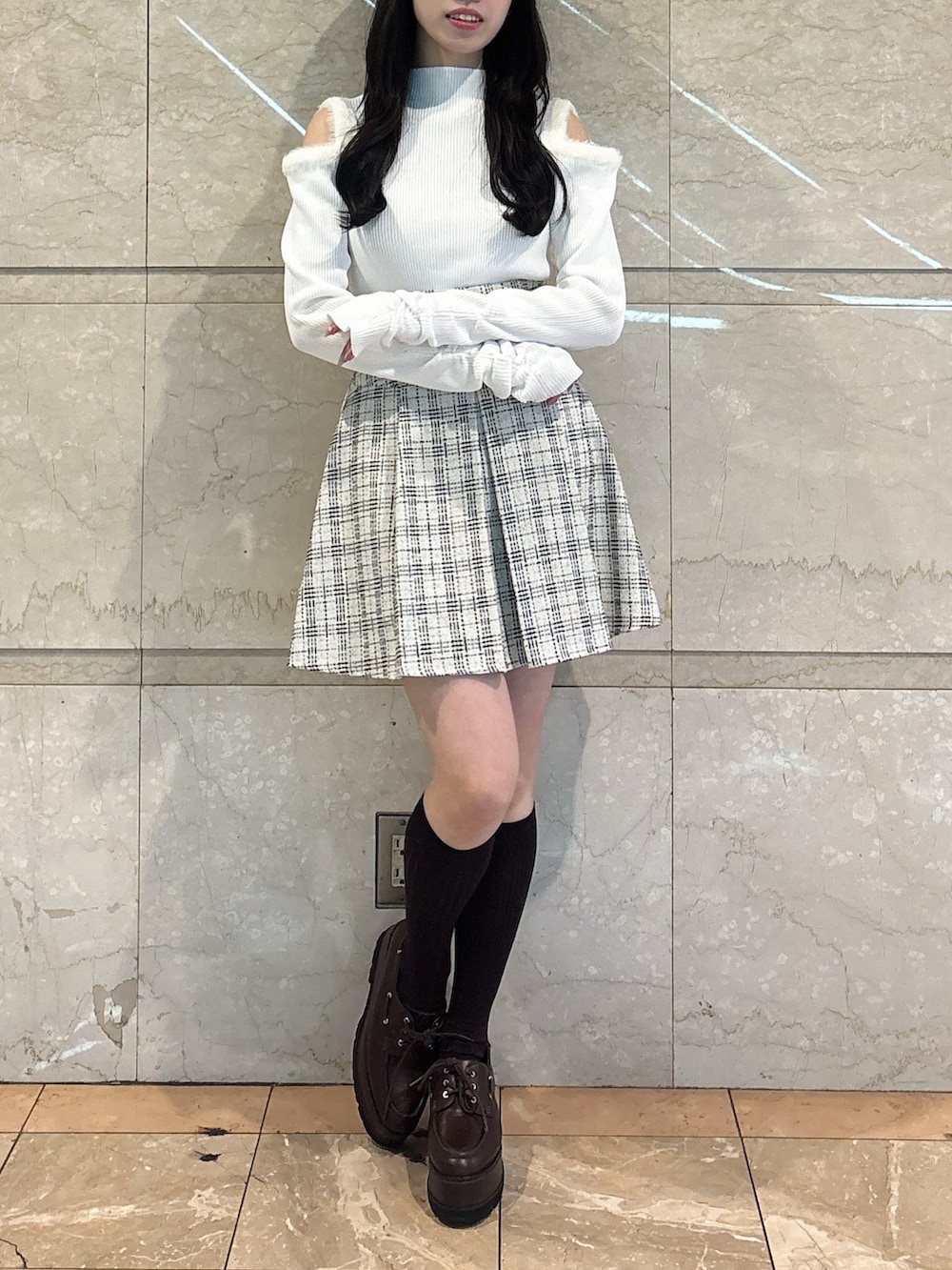 ホワイト系のニット/セーター、ホワイト系のスカート、ブラウン系のローファーを着用したレディースの冬コーディネートの3枚目の写真