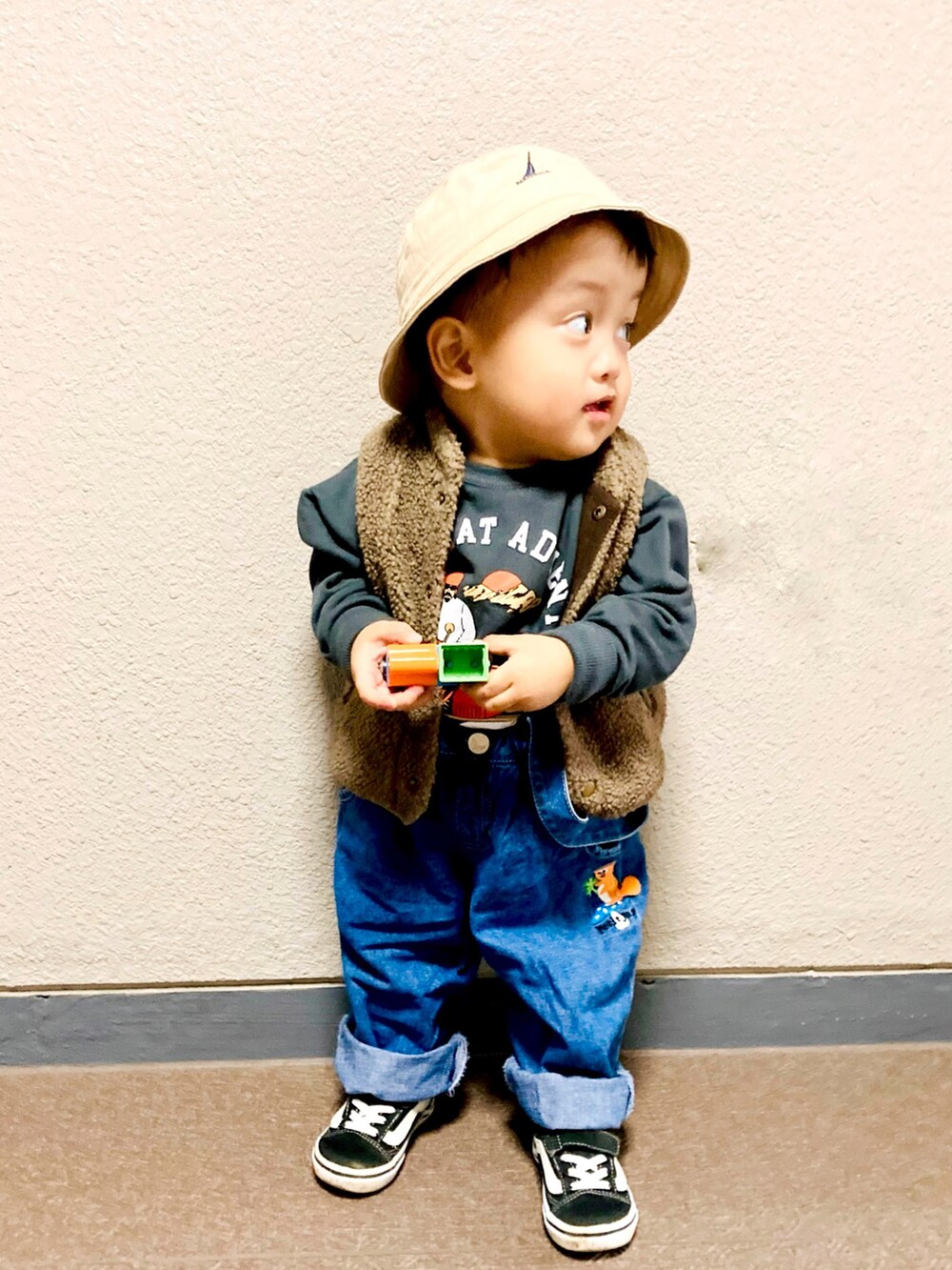 ブラウン系のベスト、ブラック系のスニーカー、グレー系のスウェットを着用したキッズの冬コーディネートの4枚目の写真