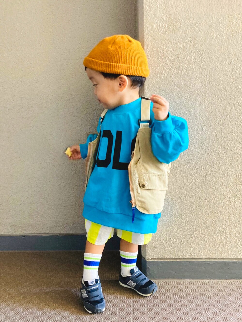 ブルー系のTシャツ/カットソー、ベージュ系のベスト、ブルー系のスニーカーを着用したキッズの秋コーディネートの3枚目の写真