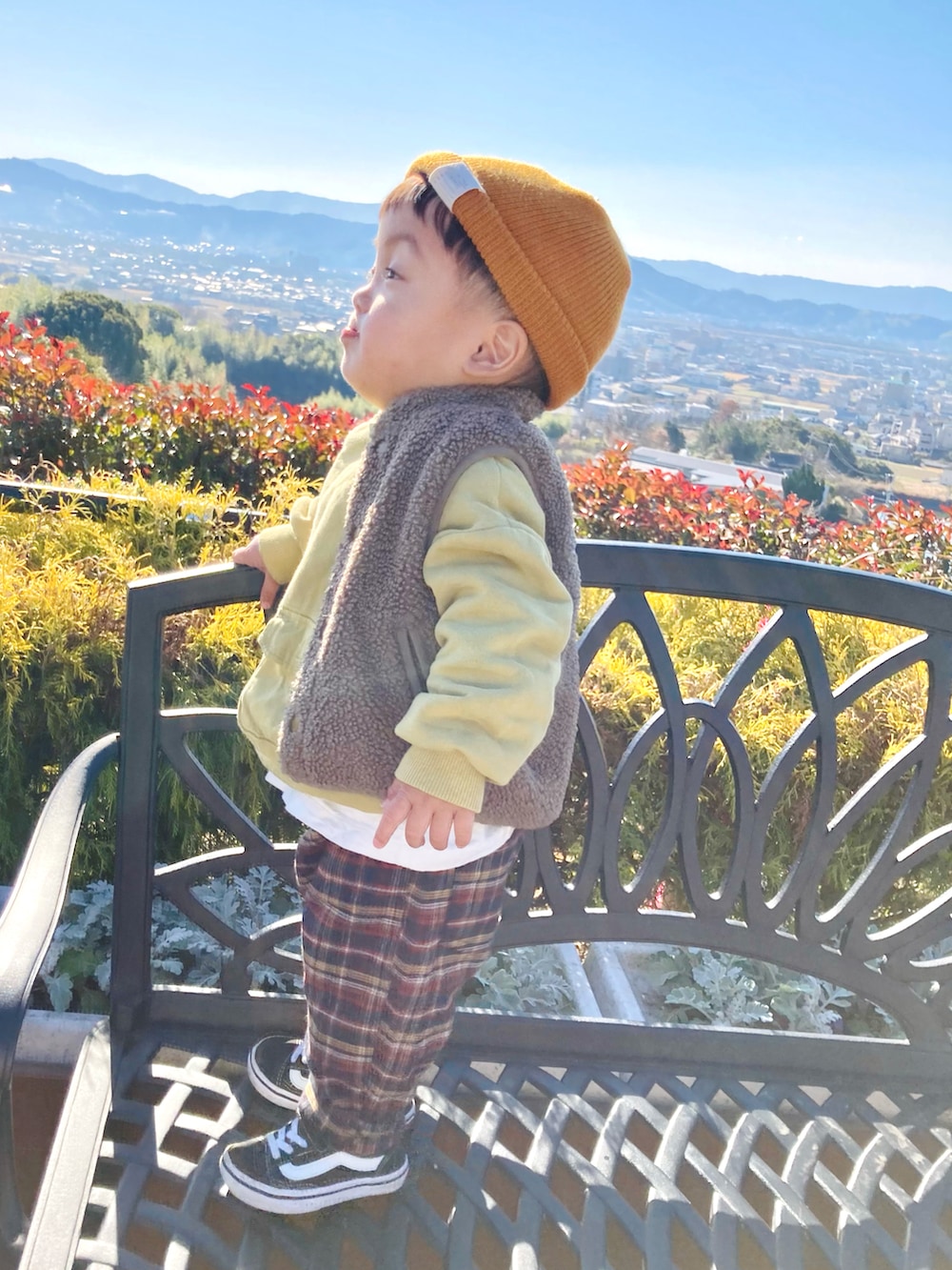 イエロー系のスウェット、ホワイト系のTシャツ/カットソー、ブラウン系のベストを着用したキッズの冬コーディネートの3枚目の写真