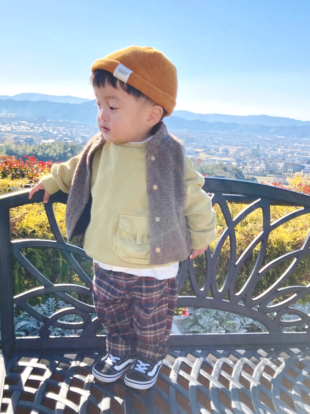 イエロー系のスウェット、ホワイト系のTシャツ/カットソー、ブラウン系のベストを着用したキッズの冬コーディネートの2枚目の写真