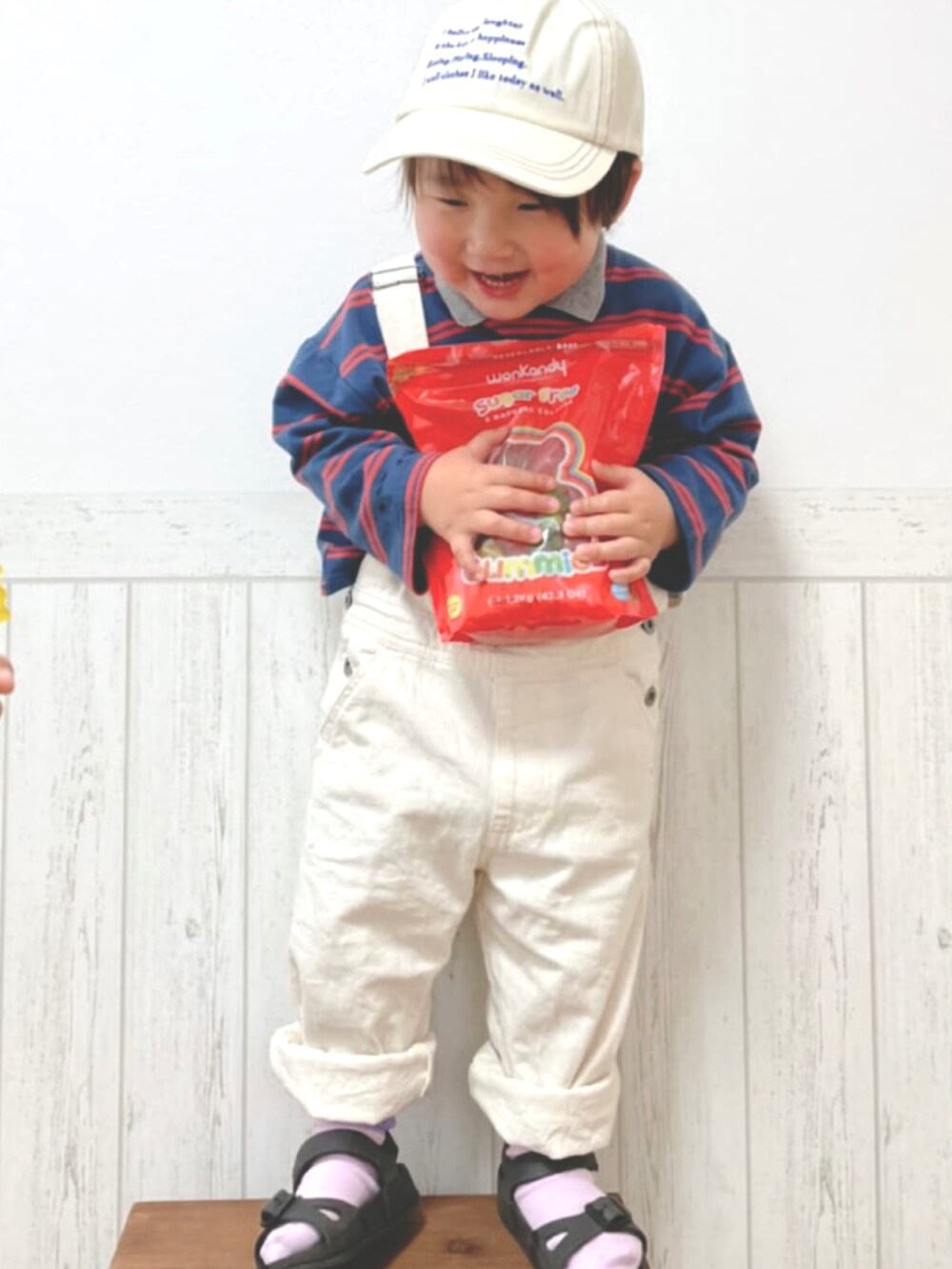 ホワイト系のオールインワン・サロペット、オレンジ系のTシャツ/カットソー、ホワイト系のスリッポンを着用したキッズの春コーディネートの4枚目の写真