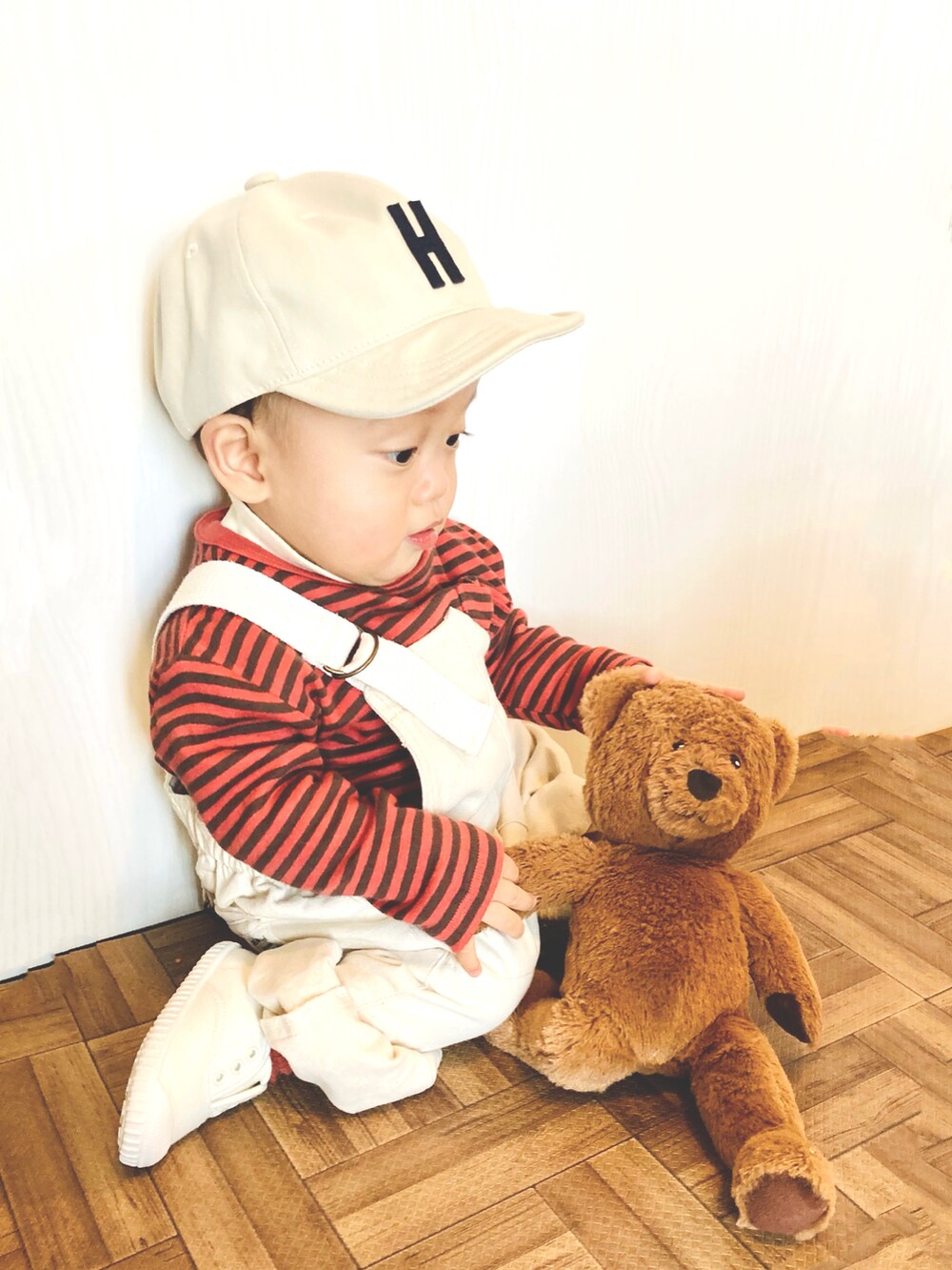 ホワイト系のオールインワン・サロペット、オレンジ系のTシャツ/カットソー、ホワイト系のスリッポンを着用したキッズの春コーディネートの3枚目の写真