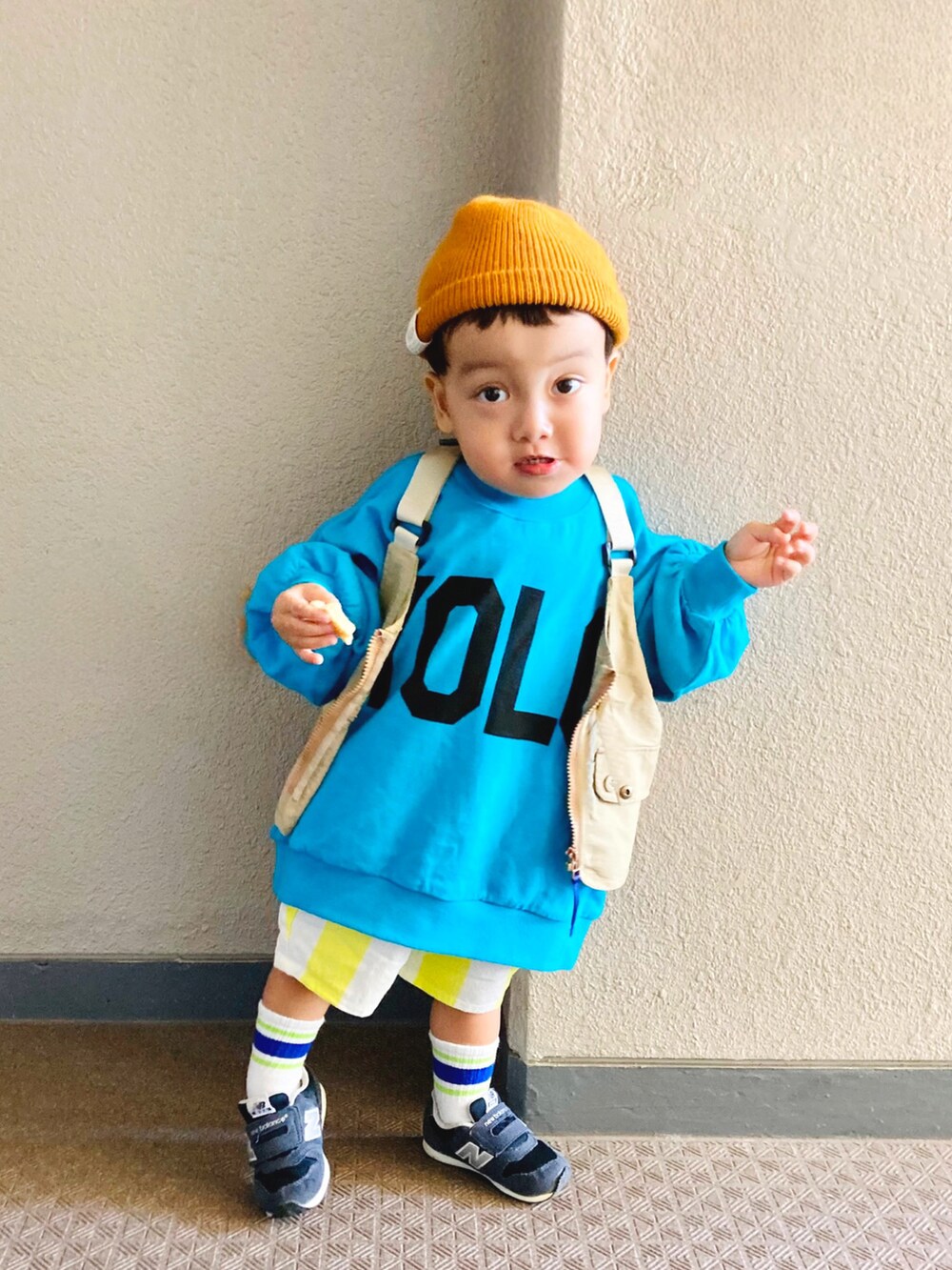 ブルー系のTシャツ/カットソー、ベージュ系のベスト、ブルー系のスニーカーを着用したキッズの秋コーディネートの2枚目の写真