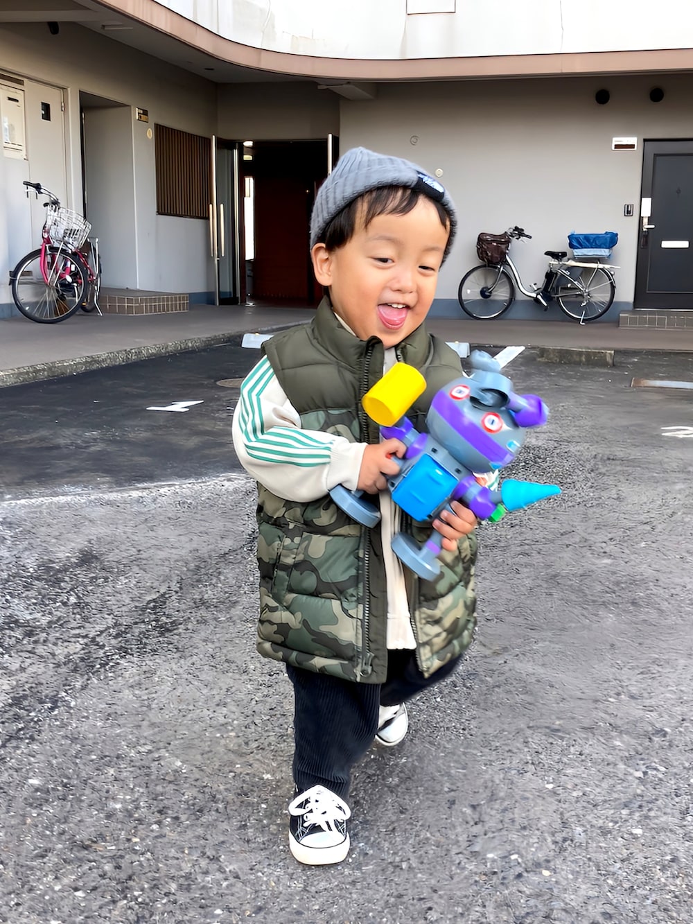 ホワイト系のその他アウター、グリーン系のジャケット/アウター、ブラック系のスニーカーを着用したキッズの冬コーディネートの3枚目の写真