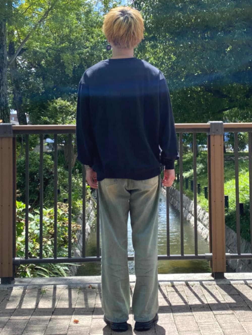 ブルー系のデニムパンツ、ブラック系のスウェットを着用したメンズの秋コーディネートの2枚目の写真