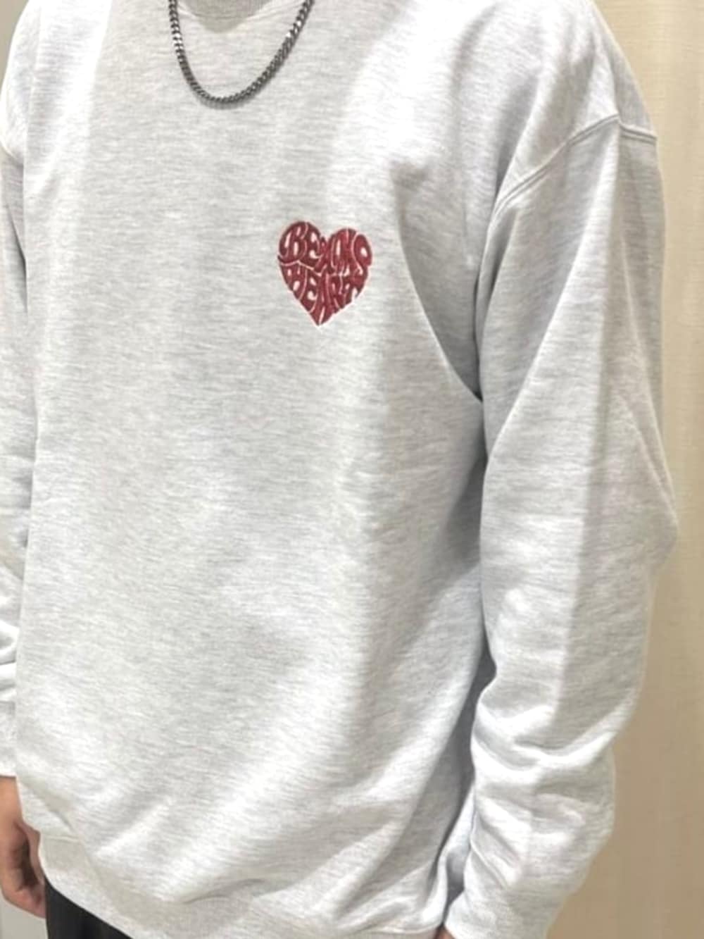 ブラウン系のスラックス、グレー系のスウェット、ブラック系のニットキャップ/ビーニーを着用したメンズの秋コーディネートの2枚目の写真