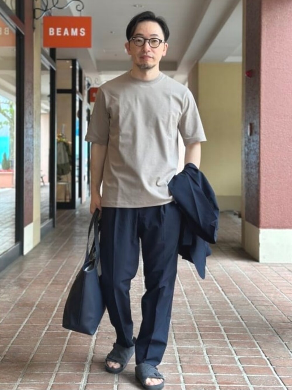 ブルー系のトートバッグ、ベージュ系のTシャツ/カットソー、ブルー系のテーラードジャケットを着用したメンズの夏コーディネートの7枚目の写真