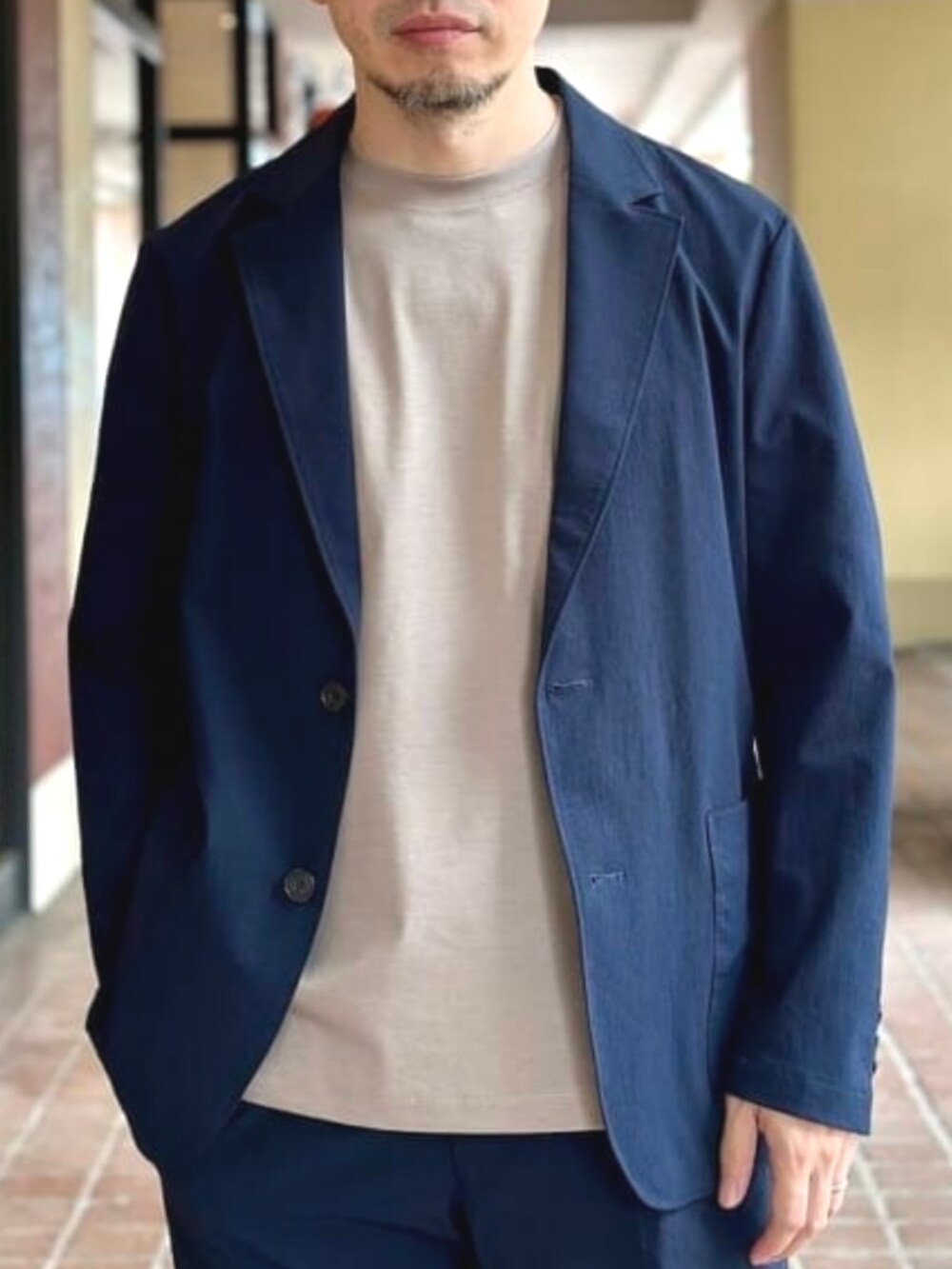 ブルー系のトートバッグ、ベージュ系のTシャツ/カットソー、ブルー系のテーラードジャケットを着用したメンズの夏コーディネートの4枚目の写真