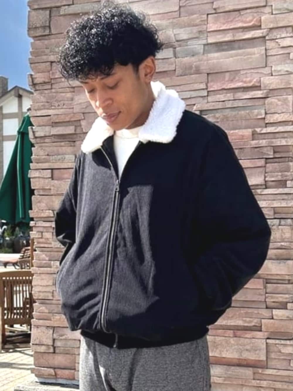 ブラック系のブルゾン、ブラウン系のその他パンツを着用したメンズの秋コーディネートの2枚目の写真