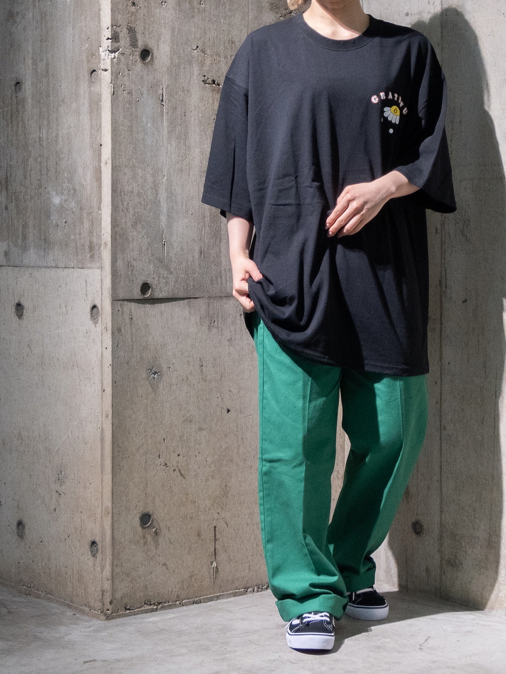 ブラック系のTシャツ/カットソー、グリーン系のチノパンツを着用したレディースの夏コーディネートの2枚目の写真