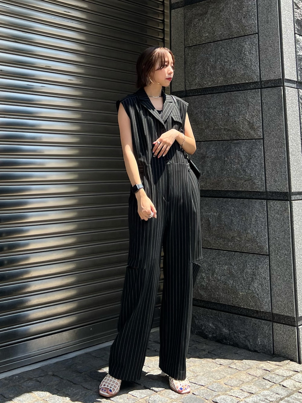 ホワイト系のサンダル、ブラック系のつなぎ/オールインワンを着用したレディースの夏コーディネートの2枚目の写真