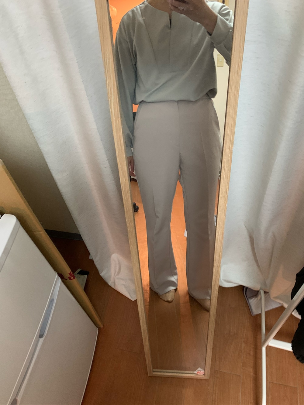 ホワイト系のスラックスを着用したレディースの秋コーディネートの2枚目の写真