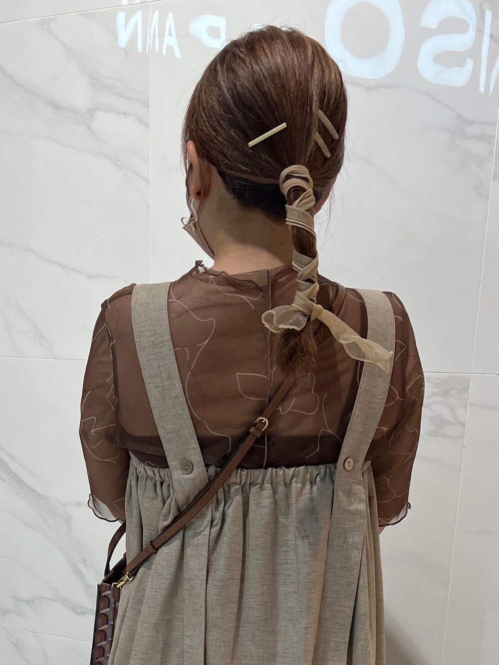 ベージュ系のワンピース、ブラウン系のショルダーバッグ、ブラウン系のTシャツ/カットソーを着用したレディースの夏コーディネートの2枚目の写真