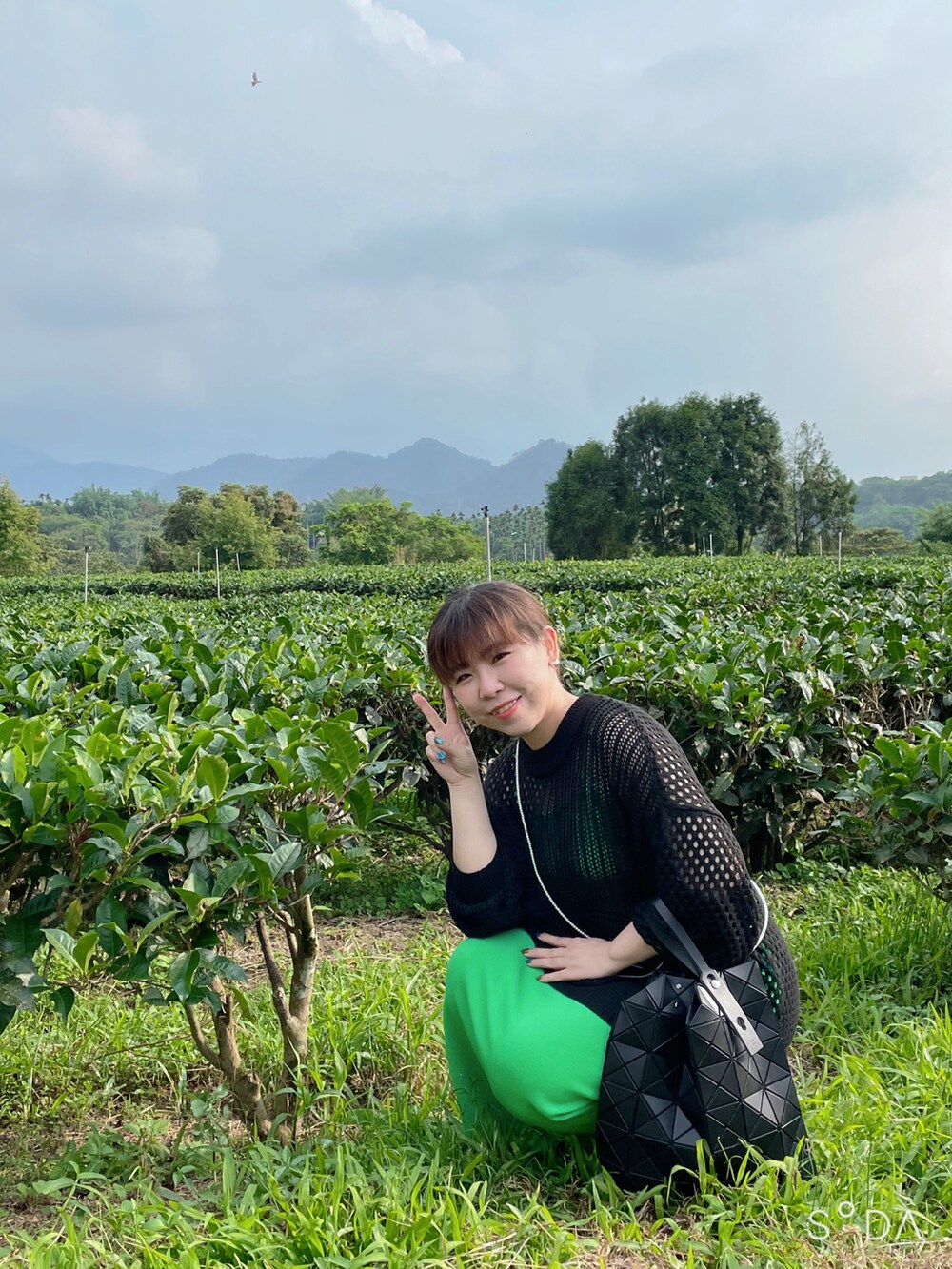 ブラック系のトートバッグ、グリーン系のワンピース、ブラック系のニット/セーターを着用したレディースの春コーディネートの3枚目の写真