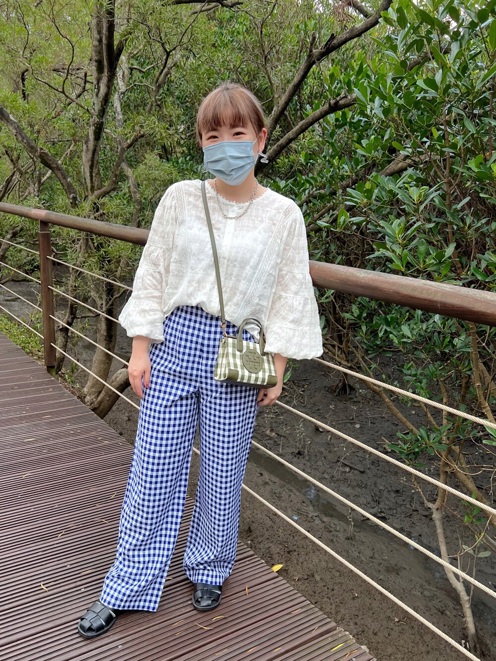 ブルー系のその他パンツ、ホワイト系のシャツ/ブラウス、グリーン系のバッグを着用したレディースの秋コーディネートの2枚目の写真