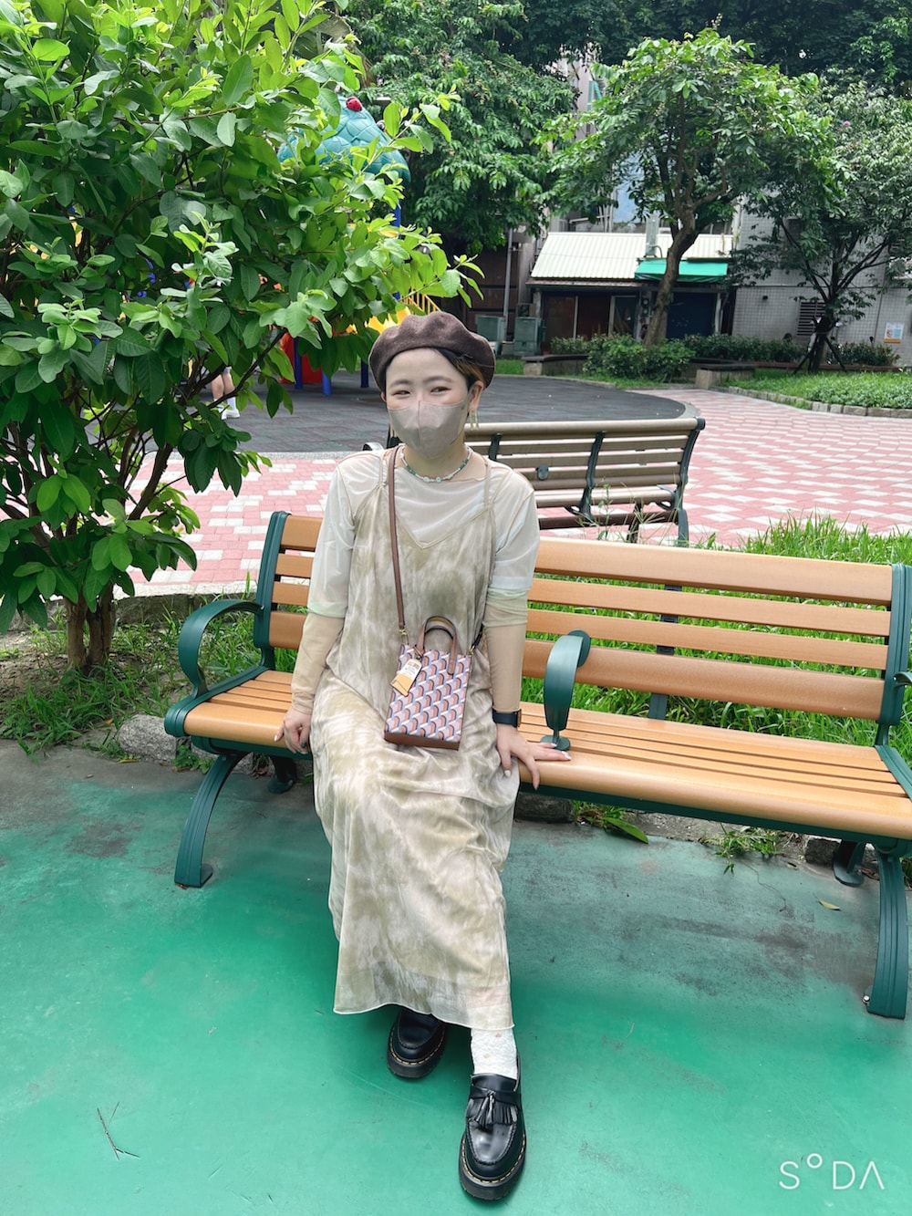 ベージュ系のワンピース、イエロー系のTシャツ/カットソー、ブラウン系のショルダーバッグを着用したレディースの夏コーディネートの2枚目の写真