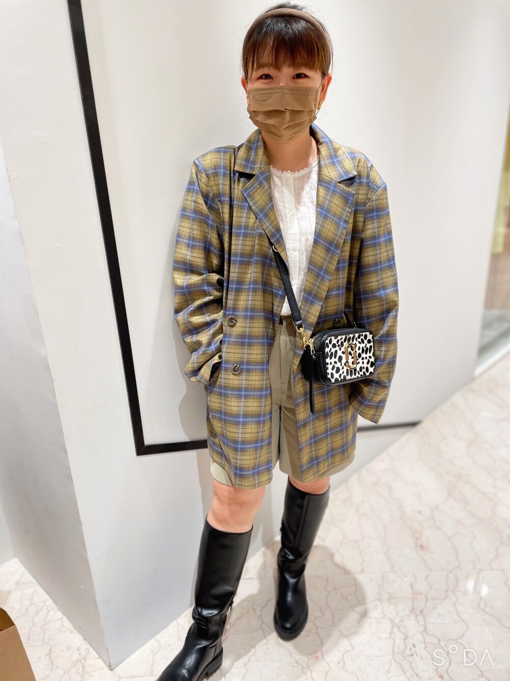 ブラック系のブーツ、ホワイト系のシャツ/ブラウス、イエロー系のテーラードジャケットを着用したレディースの春コーディネートの2枚目の写真