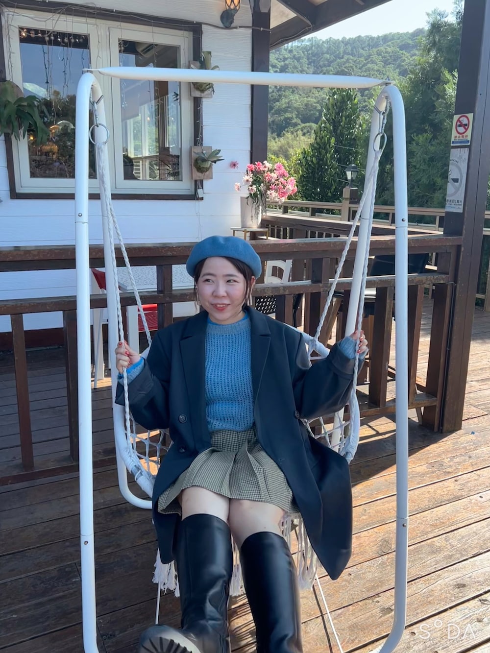 ブラック系のブーツ、ベージュ系のスカート、ブルー系のニット/セーターを着用したレディースの春コーディネートの2枚目の写真