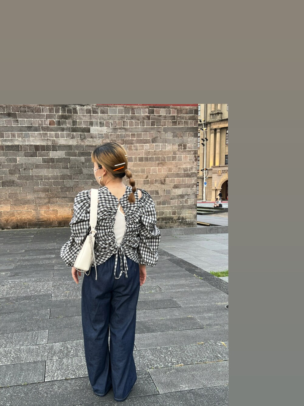 ブルー系のパンツ、グレー系のシャツ/ブラウス、ホワイト系のショルダーバッグを着用したレディースの春コーディネートの3枚目の写真