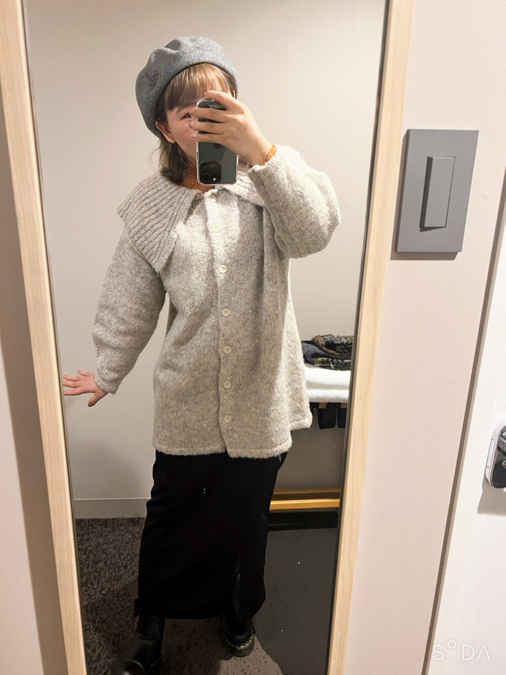 ホワイト系のムートンコート、グレー系のニット/セーター、オレンジ系のTシャツ/カットソーを着用したレディースの冬コーディネートの2枚目の写真