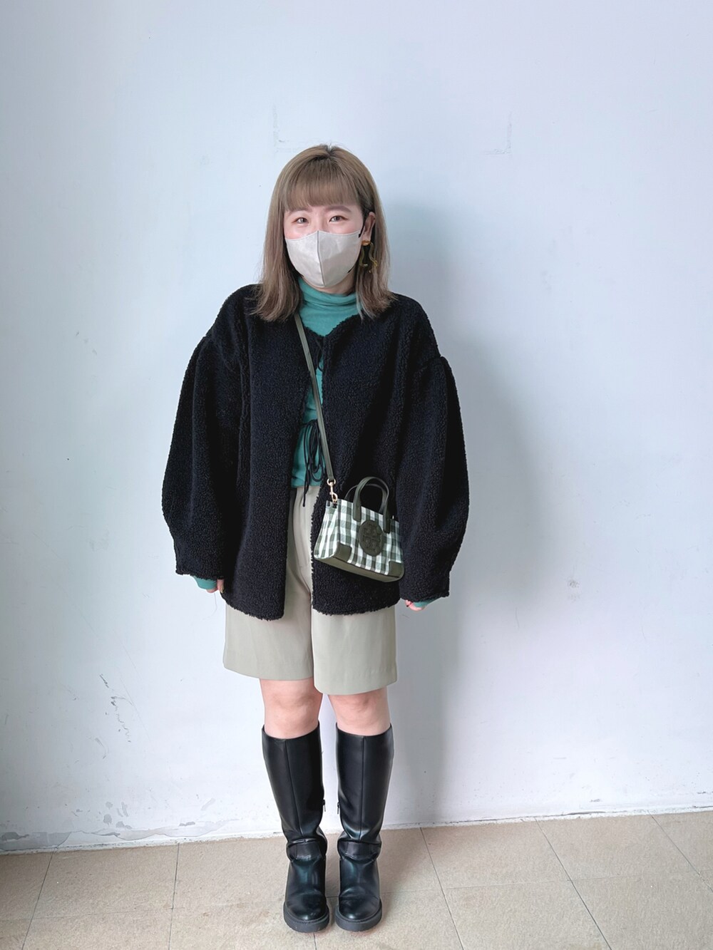 グリーン系のTシャツ/カットソー、ベージュ系のその他パンツ、ブラック系のブーツを着用したレディースの冬コーディネートの2枚目の写真