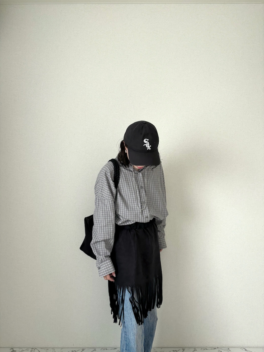 ブラック系のスカート、グレー系のシャツ/ブラウス、ブルー系のデニムパンツを着用したレディースの春コーディネートの2枚目の写真