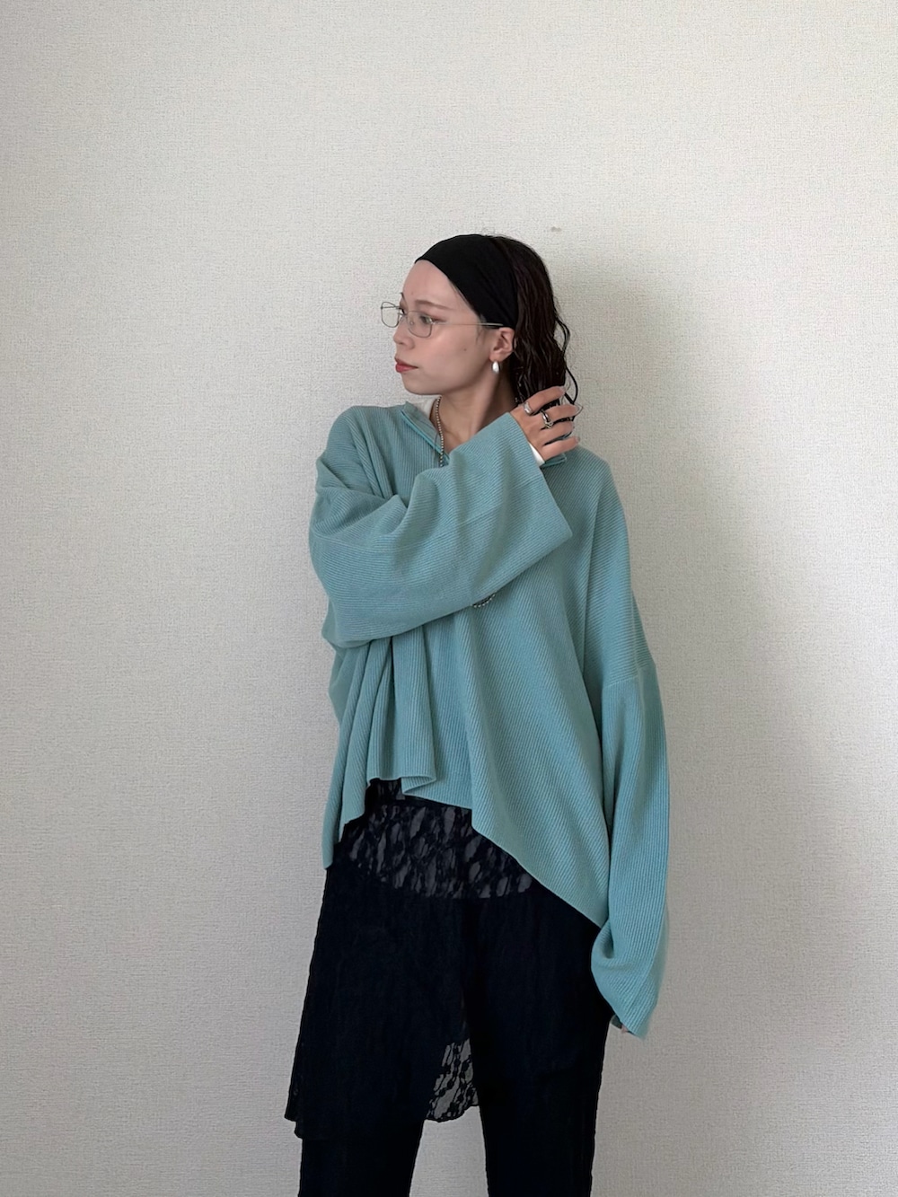 ブルー系のニット/セーター、ブラック系のその他パンツ、ホワイト系のTシャツ/カットソーを着用したレディースの春コーディネートの4枚目の写真