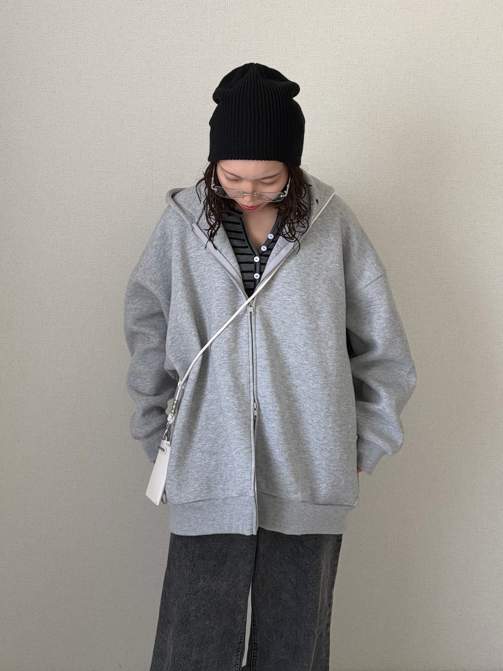 グレー系のパーカー、グレー系のデニムパンツ、ブラック系のニットキャップ/ビーニーを着用したレディースの春コーディネートの5枚目の写真