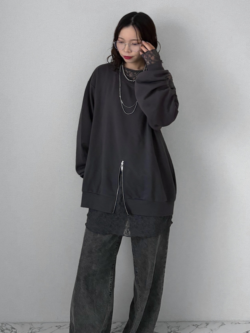 ブラック系のデニムパンツ、グレー系のスニーカー、ブラック系のトップスを着用したレディースの春コーディネートの2枚目の写真