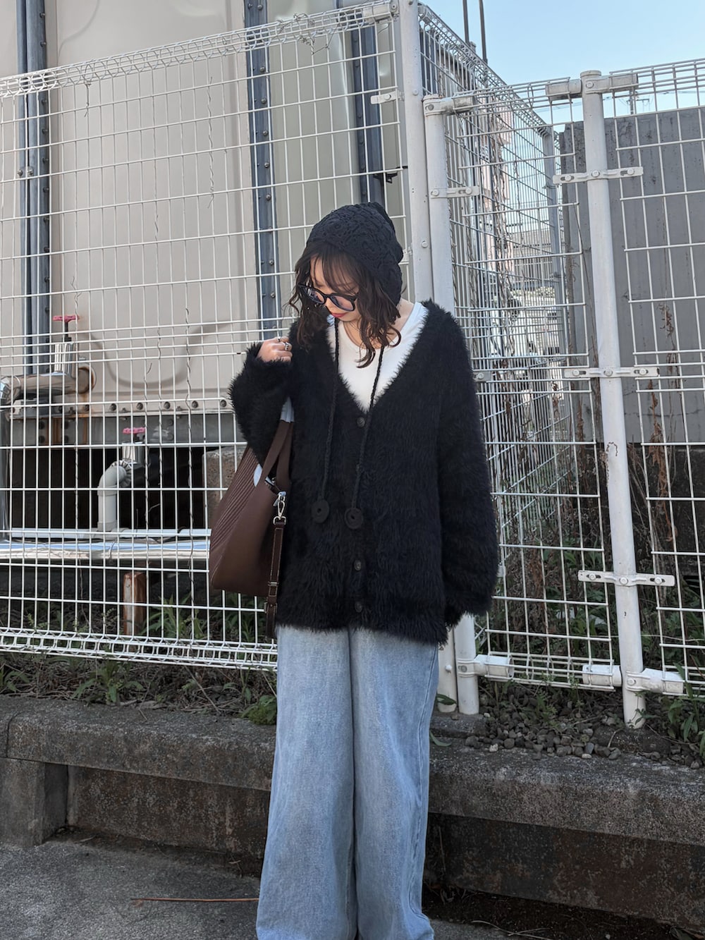 ブルー系のデニムパンツ、ブラック系のカーディガン/ボレロ、ホワイト系のTシャツ/カットソーを着用したレディースの春コーディネートの4枚目の写真