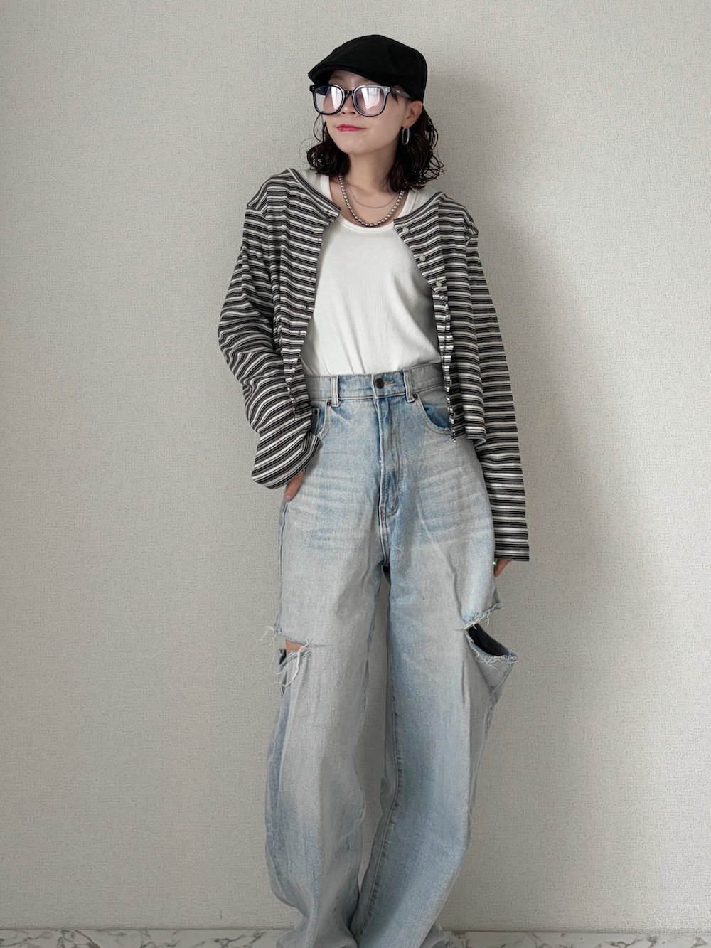 ホワイト系のTシャツ/カットソー、グレー系のカーディガン/ボレロ、ブルー系のデニムパンツを着用したレディースの春コーディネートの2枚目の写真