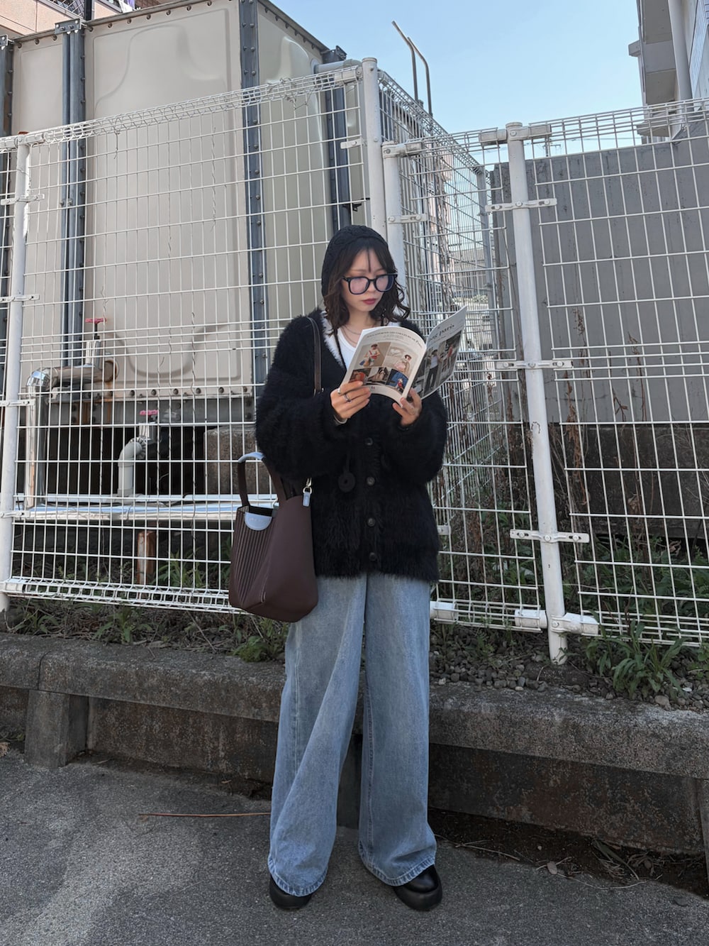 ブルー系のデニムパンツ、ブラック系のカーディガン/ボレロ、ホワイト系のTシャツ/カットソーを着用したレディースの春コーディネートの5枚目の写真