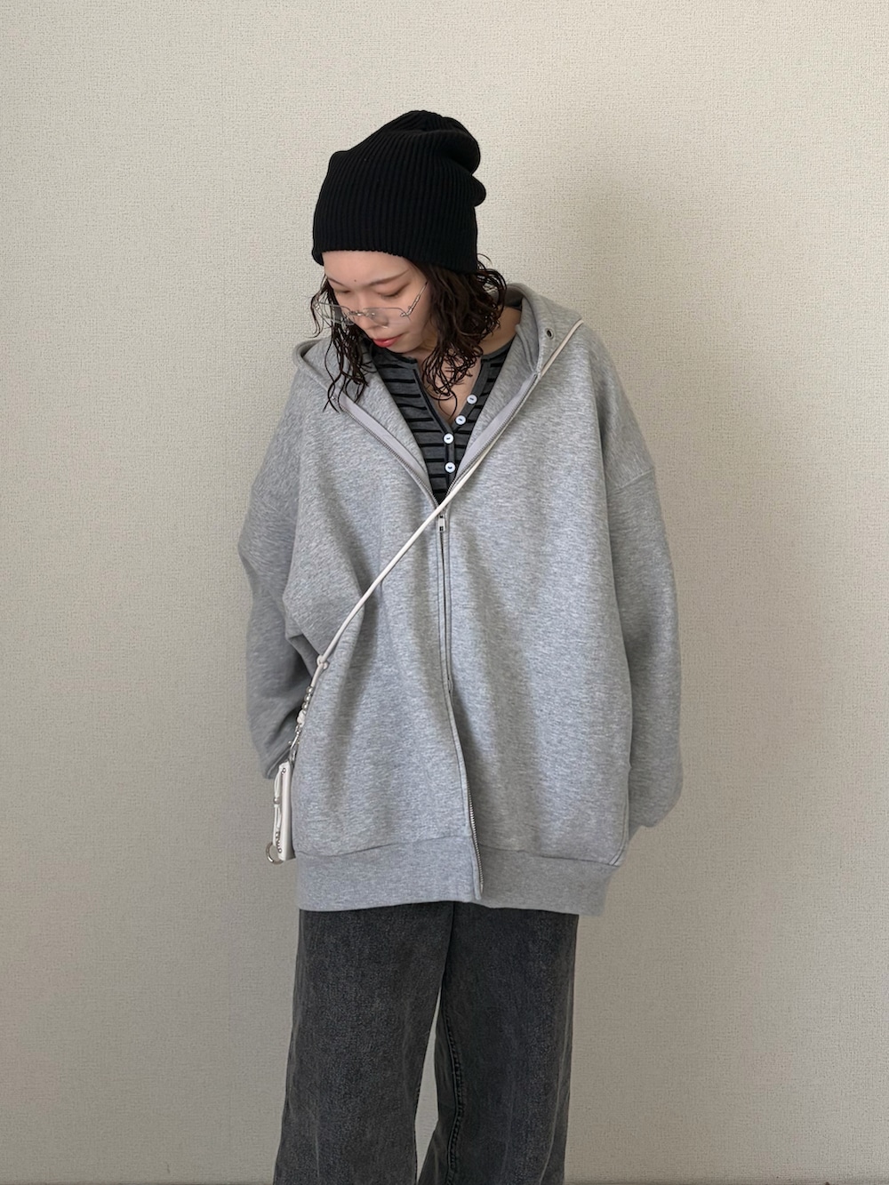 グレー系のパーカー、グレー系のデニムパンツ、ブラック系のニットキャップ/ビーニーを着用したレディースの春コーディネートの4枚目の写真