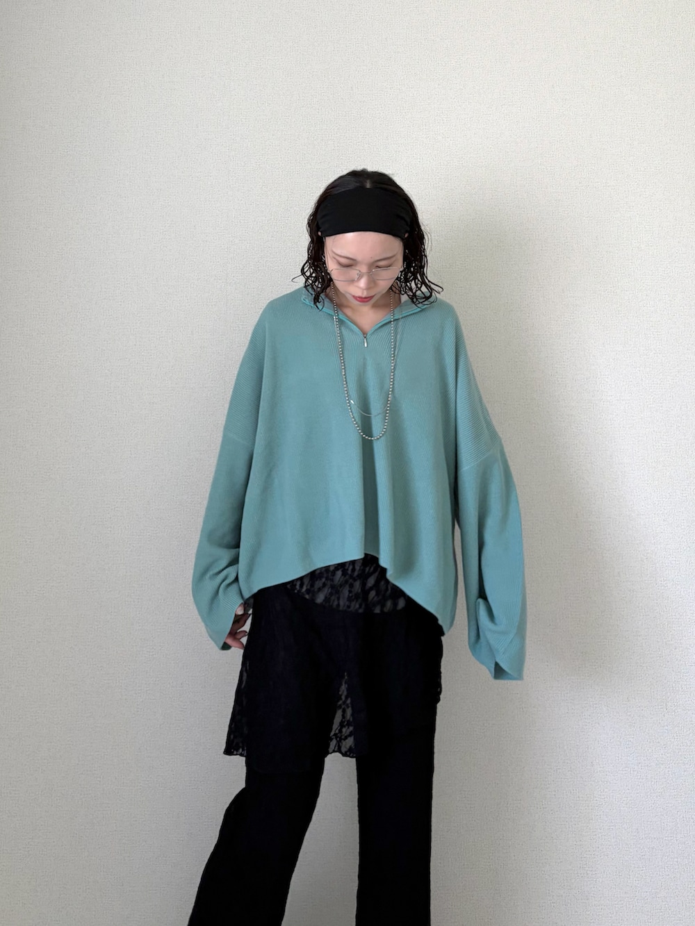 ブルー系のニット/セーター、ブラック系のその他パンツ、ホワイト系のTシャツ/カットソーを着用したレディースの春コーディネートの2枚目の写真