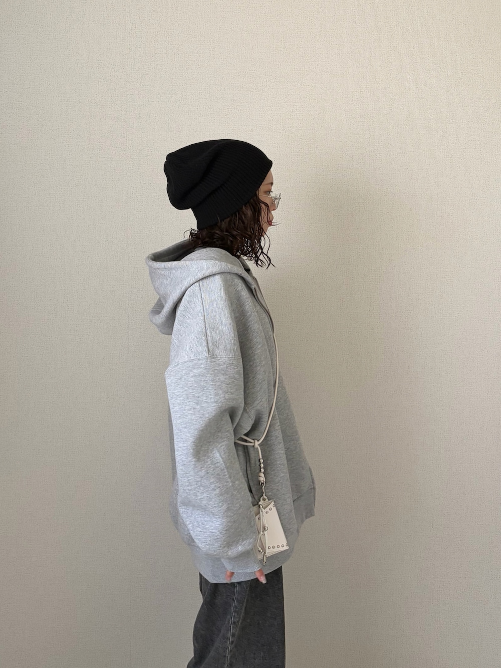 グレー系のパーカー、グレー系のデニムパンツ、ブラック系のニットキャップ/ビーニーを着用したレディースの春コーディネートの3枚目の写真