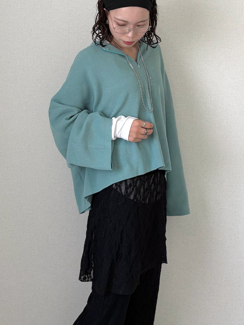 ブルー系のニット/セーター、ブラック系のその他パンツ、ホワイト系のTシャツ/カットソーを着用したレディースの春コーディネートの5枚目の写真