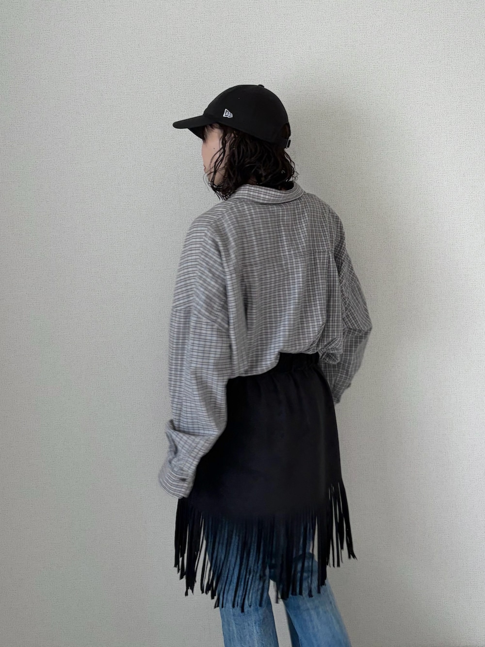 ブラック系のスカート、グレー系のシャツ/ブラウス、ブルー系のデニムパンツを着用したレディースの春コーディネートの5枚目の写真