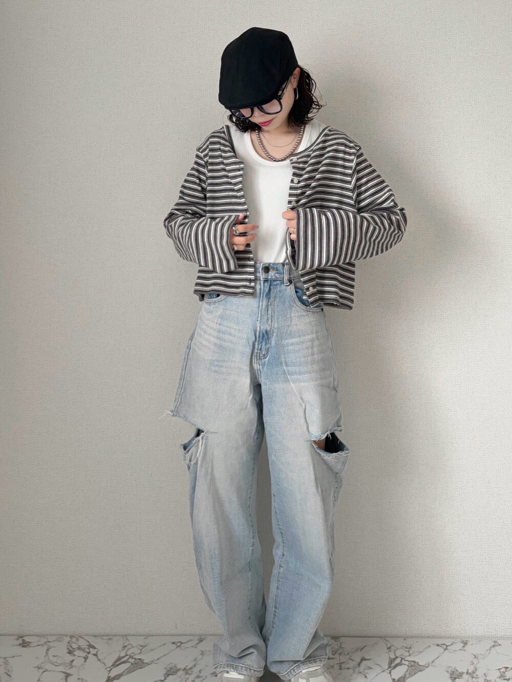 ホワイト系のTシャツ/カットソー、グレー系のカーディガン/ボレロ、ブルー系のデニムパンツを着用したレディースの春コーディネートの4枚目の写真