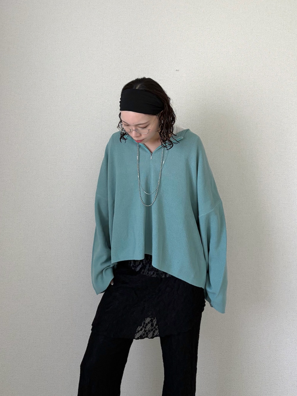 ブルー系のニット/セーター、ブラック系のその他パンツ、ホワイト系のTシャツ/カットソーを着用したレディースの春コーディネートの3枚目の写真