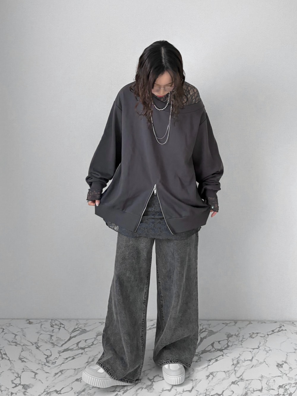 ブラック系のデニムパンツ、グレー系のスニーカー、ブラック系のトップスを着用したレディースの春コーディネートの3枚目の写真