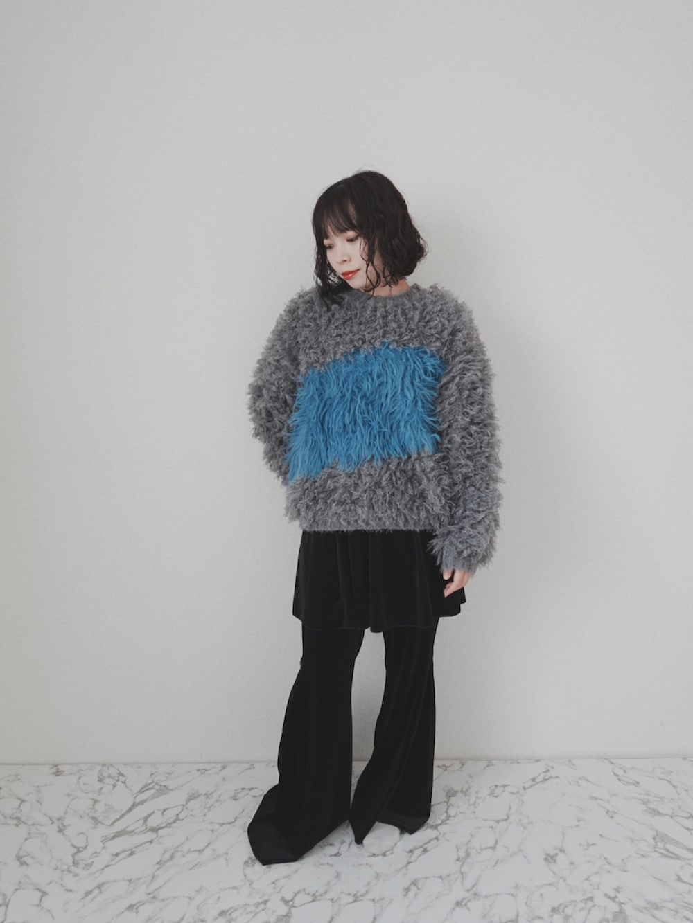 グレー系のニット/セーター、ブラック系のその他パンツを着用したレディースの冬コーディネートの3枚目の写真