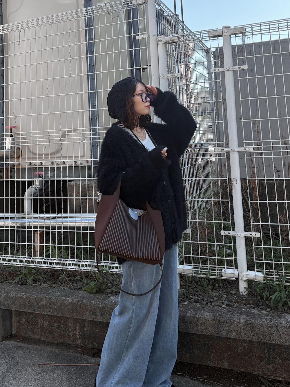 ブルー系のデニムパンツ、ブラック系のカーディガン/ボレロ、ホワイト系のTシャツ/カットソーを着用したレディースの春コーディネートの2枚目の写真